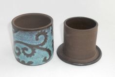 two brown and blue vases sitting next to each other