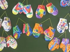 colorful paper mitts are hanging on a string