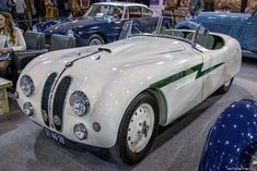 an old fashioned car is on display at a showroom with other cars in the background