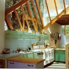 a kitchen with green walls and wooden roof