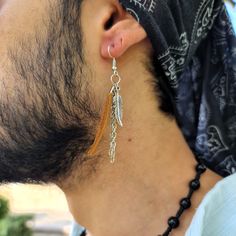 Mens Edgy & Boho Earring Collection, Personalized Minimalist Designs with Chain Long, Feather, Fringe, Tassel, and Leather Accents - Pirate, Cowgirl & Boho Jewelry Styles - Perfect for the Modern Dangle Earring Enthusiast. Dive into the world of bohemian style with this meticulously designed Men's Leather fringe tassel earring. Delicately adorned with a silver-plated chain and a feather at the end, it radiates a touch of edgy charm and boho flair - a perfect blend of bohemian tassel earrings and Casual Single Dangle Earring, Mens Dangle Earrings, Earrings Men, Minimalist Earring, Edgy Accessories, Tassel Earring, Earring Stand, Boho Style Jewelry, Mens Leather