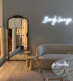 a living room filled with furniture and a large mirror on top of a wall next to a table