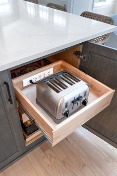 a toaster is sitting in the middle of a drawer under a kitchen counter top