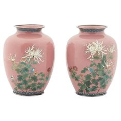 two pink vases with flowers and birds painted on the sides, one is larger than the other