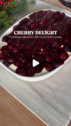 a white bowl filled with cranberry sauce on top of a wooden table next to a christmas tree