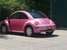 a pink car is parked in a parking lot