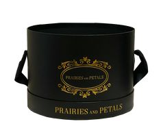 a black box with gold lettering on the lid and handles that says prairies and petals