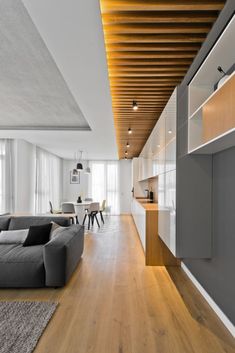 a living room filled with furniture next to a kitchen and dining room table on top of a hard wood floor