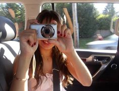 a woman taking a photo in the back seat of a car