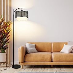 a living room with a couch, lamp and potted plant