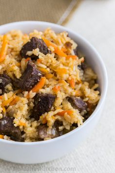 a white bowl filled with rice and meat