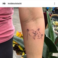 a woman's arm with a tattoo on it that has a cat and dog