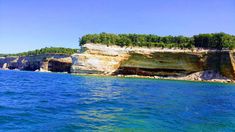 the water is very blue and clear with some cliffs on it's sides in the distance