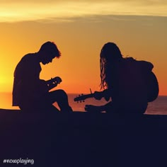 two people are sitting on the beach playing guitars at sunset with the sun setting in the background