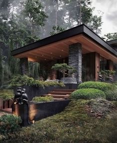 a modern house in the woods surrounded by trees and bushes with stairs leading up to it