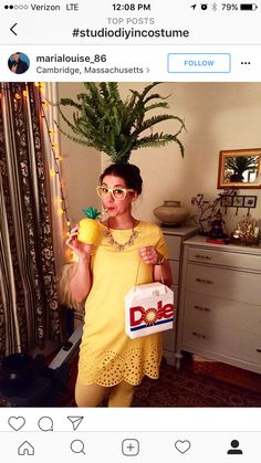 a woman in yellow dress holding a bag and wearing glasses with palm tree behind her