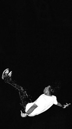 a man flying through the air while riding on top of a skateboard at night