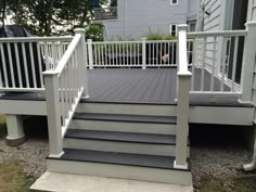 a porch with white railing and steps leading up to the house