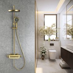 a bathroom with a toilet, sink and shower head in gold fixtures on the wall