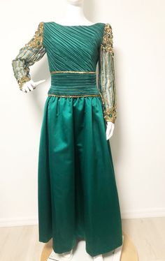 This is a stunning gown from Lillie Rubin and George F. Couture. The dress is a gorgeous shade of green accented with gold sequins and bugle beads at the waistline. The sleeves are sheer and hand beaded with jewels and sequins. You will certainly feel like a princess wearing this one. Long zipper in back, lined tulle skirt for fullness. Size tag 6, check measurements carefully, no stretch. Made in USA. Measurements taken with dress laying flat and doubled where appropriate. In order to determine Green Evening Dress With Fitted Bodice, Fitted Green Sequin Evening Dress, Green Fitted Bodice Floor-length Evening Dress, Green Floor-length Evening Dress With Fitted Bodice, Green Evening Dress With Fitted Bodice For Prom, Green Gown For Gala Or Prom Season, Green Gown For Gala And Prom Season, Green Gown For Gala During Prom Season, Green Fitted Ball Gown Evening Dress