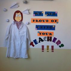 a white lab coat hanging on the wall next to a teacher's cutout