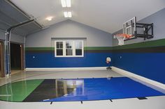 an indoor basketball court with blue and green paint