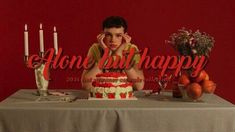 a young boy sitting at a table with a cake and candles in front of him