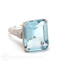 "An absolutely stunning antique style Aquamarine ring with a lovely 11.00 carat natural emerald cut Aquamarine set in a beautiful floral filigree Art Nouveau setting inspired by ring designs of the 1900's. This is a large Aqua ring, a true statement right hand ring or engagement ring. It's available in 14K White, Yellow or Rose Gold. Made to order. Please allow three to four weeks for delivery. Aquamarine is best known for its breathtaking range of blue colors and belongs to the same family as E Jewerly Rings, Antique Aquamarine Ring, Art Nouveau Engagement Ring, Emerald Cut Aquamarine Ring, Aqua Ring, Art Nouveau Ring, Rings Ideas, Right Hand Ring, Sweet Jewelry