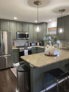 a large kitchen with stainless steel appliances and granite counter tops, along with dark wood flooring