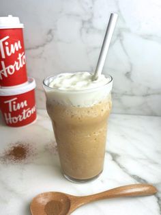 there is a drink with whipped cream in it and a wooden spoon next to it