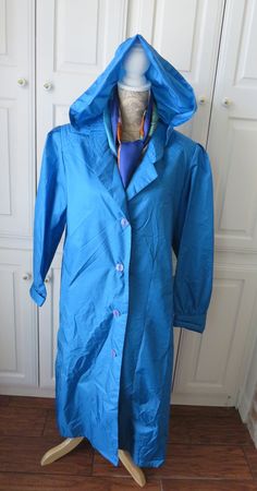 "You'll love the way this nylon vintage raincoat by TOTES, folds so nicely to fit within your luggage or vehicle.  Always ready for those unexpected showers!!   Simple and fashionable, this awesome turquoise blue raincoat buttons up the front with 4 buttons, two front slit pockets, a matching half belt, padded shoulders,  three extra buttons and the best part, a detachable hood for those rainy days! You'll look so slick, you'll be ready for it to rain!   Maker:  The TOTES Coat  Size:  14P (Our M Vintage Raincoat, Rain Slicker, Blue Raincoat, Vintage Clothes Women, Raincoats For Women, Bleu Turquoise, Rain Coat, Detachable Hood, Rainy Days