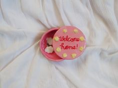 a pink bowl with welcome home written on it and some marshmallows in it