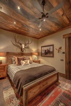 a bed room with a neatly made bed and a ceiling mounted deer head on the wall