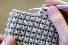 someone is crocheting the side of a small piece of cloth with a needle