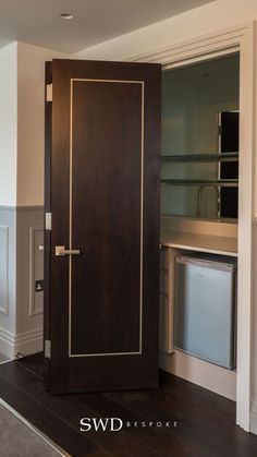 an empty room with a wooden door in the center and shelves on the other side