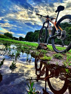 a bike is parked on the edge of a puddle