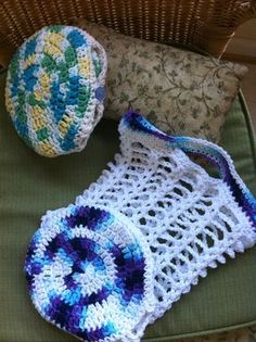 two crocheted purses sitting on top of a green chair next to a pillow