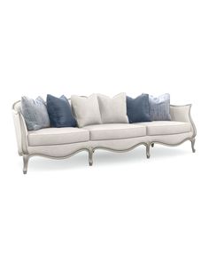 a white couch with blue pillows on the top and bottom, in front of a white background