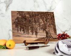 a wooden cutting board sitting on top of a counter next to some fruit and vegetables