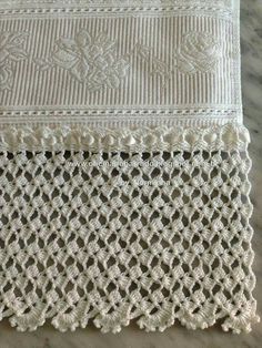 two pieces of white crocheted fabric on top of a marble tablecloths