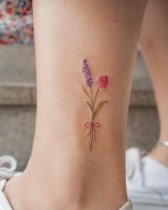 a small tattoo on the ankle of a woman with flowers in her left side ribcage