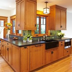 a large kitchen with wooden cabinets and black counter tops, along with an island in the middle