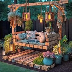 a wooden bench sitting under a tree next to a lush green field with lots of plants