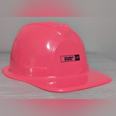 a pink hard hat sitting on top of a table