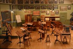 a room filled with lots of wooden furniture and pictures on the wall above it's windows