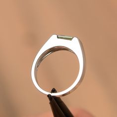 It is a green sapphire ring. The main stone is 5 mm*7 mm emerald cut.weight about 1.20 carats. The basic metal is sterling silver and plated with rhodium/14k white gold/14k rose gold/14k yellow gold You can also go to my shop Home for more elegant rings: https://www.etsy.com/shop/godjewelry?ref=hdr_shop_menu Customization is always welcome and please feel free to contact with me if you have any design ideas! Modern Emerald Cut May Birthstone Jewelry, Modern Asscher Cut Emerald Promise Ring, Minimalist Emerald Cut Green Jewelry, Modern Sterling Silver Emerald Cut Sapphire Ring, Modern Green Emerald-cut Jewelry, Modern Emerald Ring With Baguette Cut And Prong Setting, Modern Emerald Ring With Baguette Cut, Modern Baguette Cut Emerald Ring For May Birthstone, Modern White Gold Emerald Ring With Baguette Cut