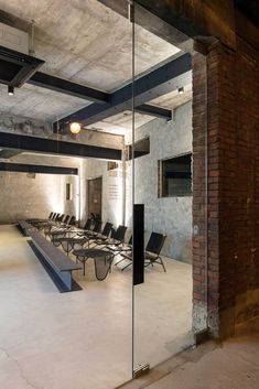 an empty conference room with chairs and brick walls in the background, as seen through glass doors