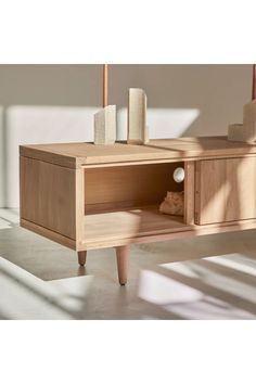 an entertainment center with two candles on top and some rocks in the bottom drawer next to it