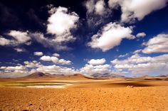 the desert is full of sand and clouds