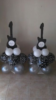 two black and white balloons sitting on top of each other in front of a wall